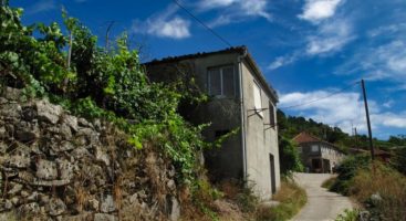 Casa de piedra a rehabilitar con pequeño jardín en la ribera del río Miño