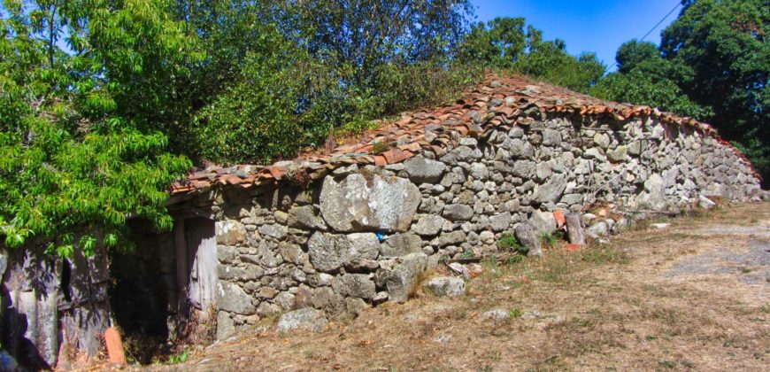Bonita casa tradicional de piedra con fincas y cobertizo