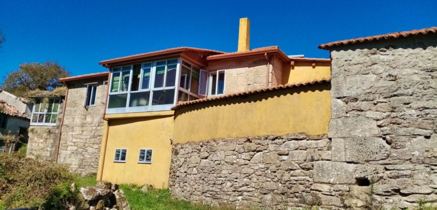 Uit natuursteen opgetrokken huis met patio en tuin